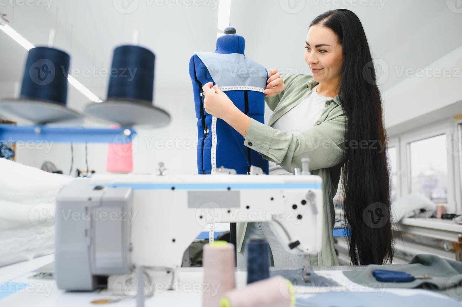 jovem mulher trabalhando Como costureira dentro roupas fábrica. foto