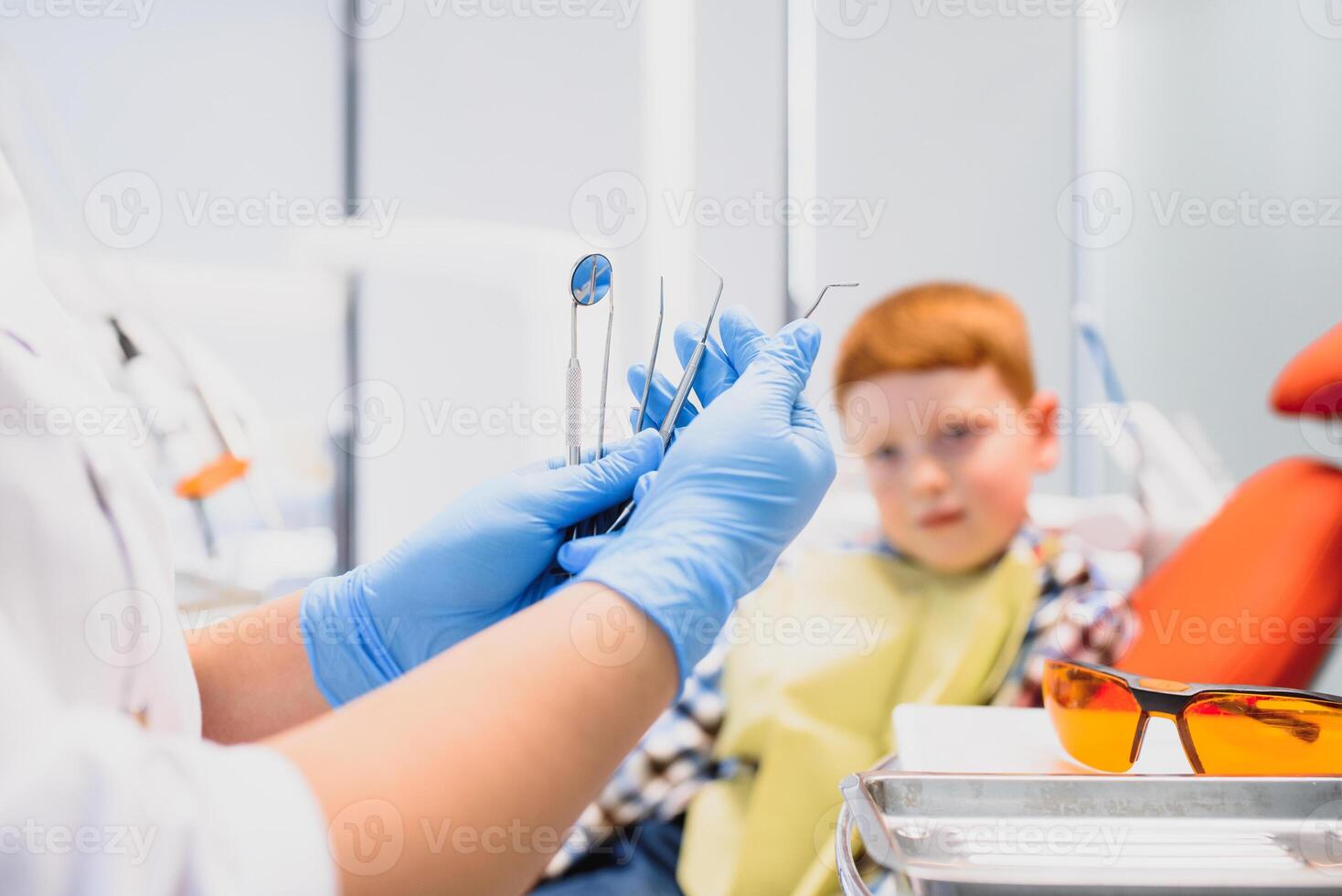 retrato do uma dentista segurando dental instrumentos dentro dele mãos dentro a clínica fechar-se foto