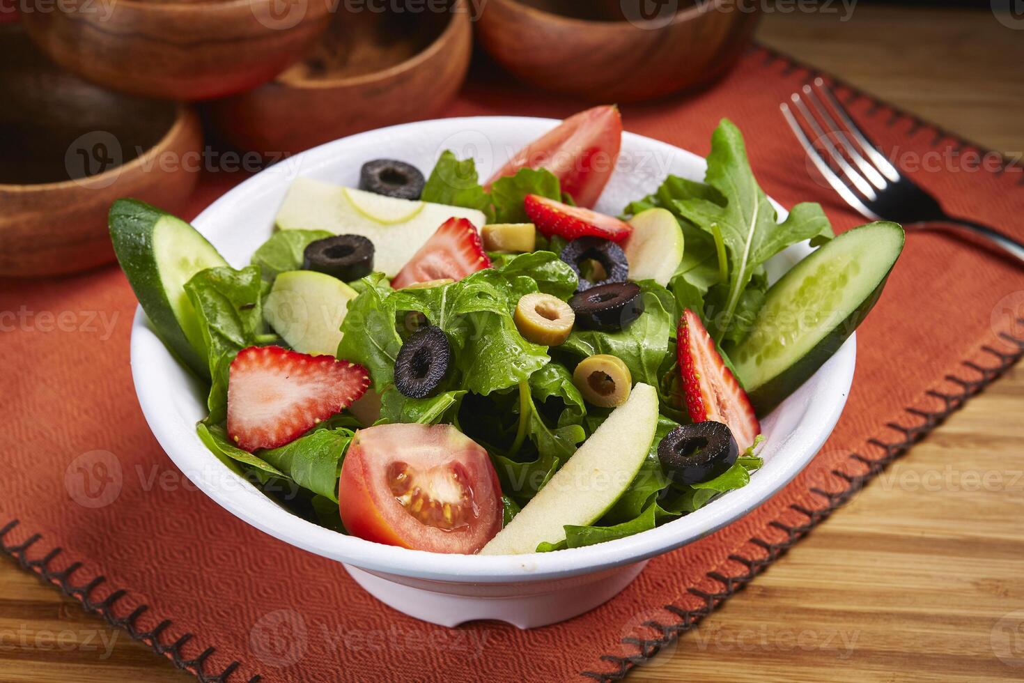 fresco Rocca salada com pepino, tomate, morango, Oliva e folha servido dentro tigela isolado em mesa lado Visão do meio leste Comida foto