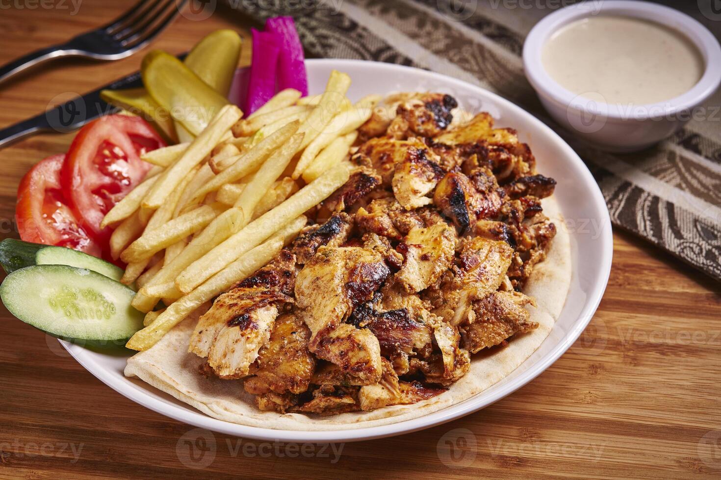 árabe frango shawarma prato com fritas servido dentro prato isolado em mesa lado Visão do meio leste Comida foto