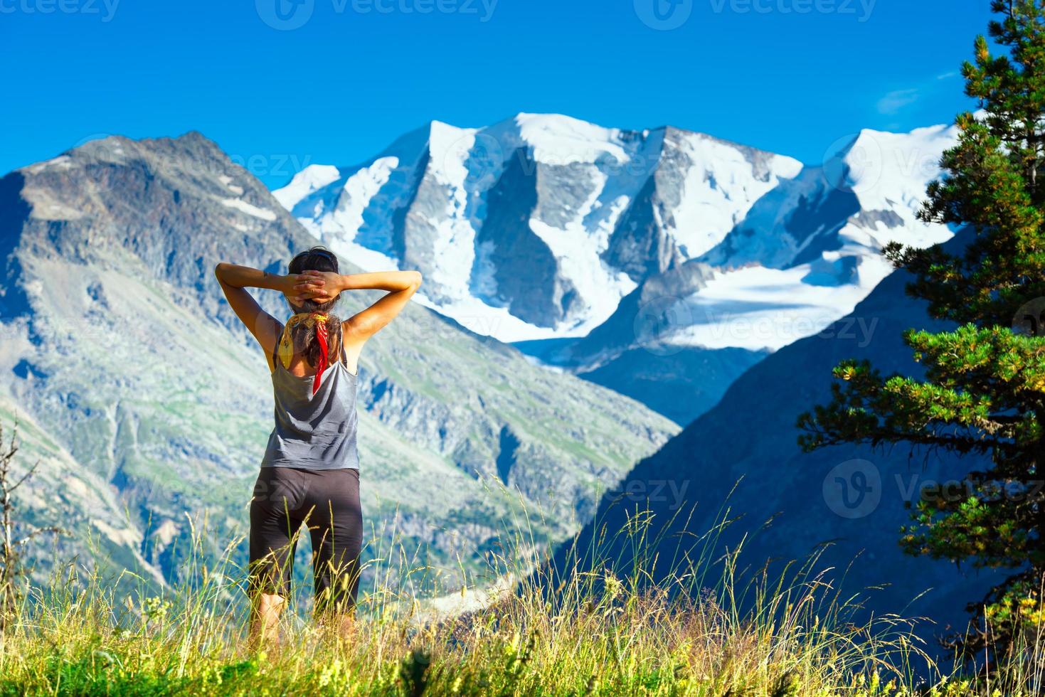 menina olha para as altas montanhas durante uma caminhada foto