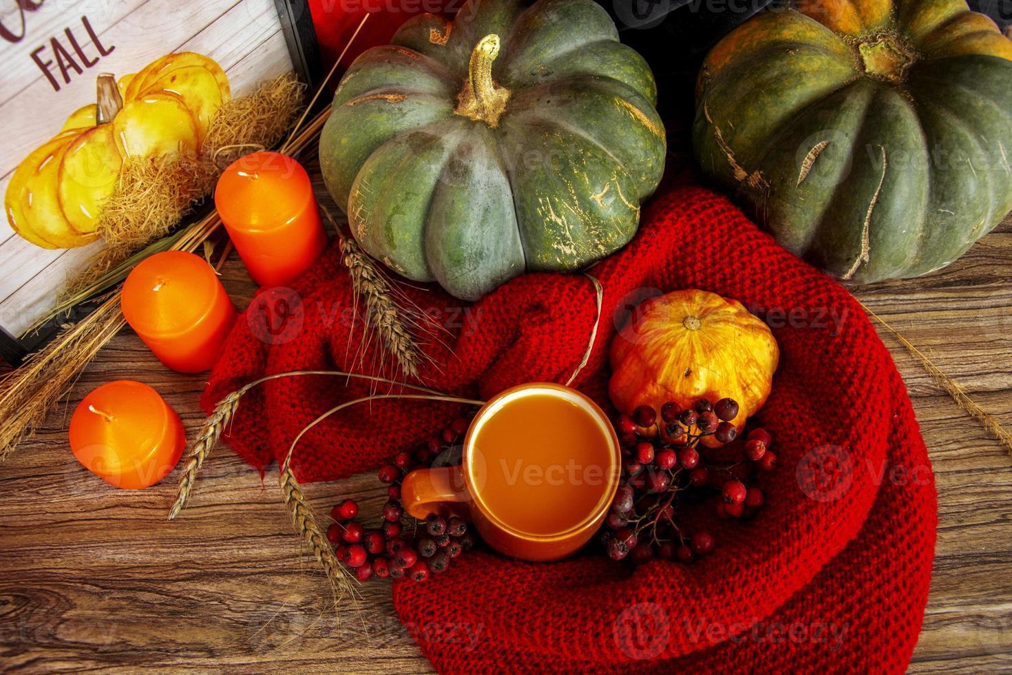 dia das bruxas ainda vida. abóboras, velas laranja e um copo de suco de abóbora em um lenço vermelho. foto