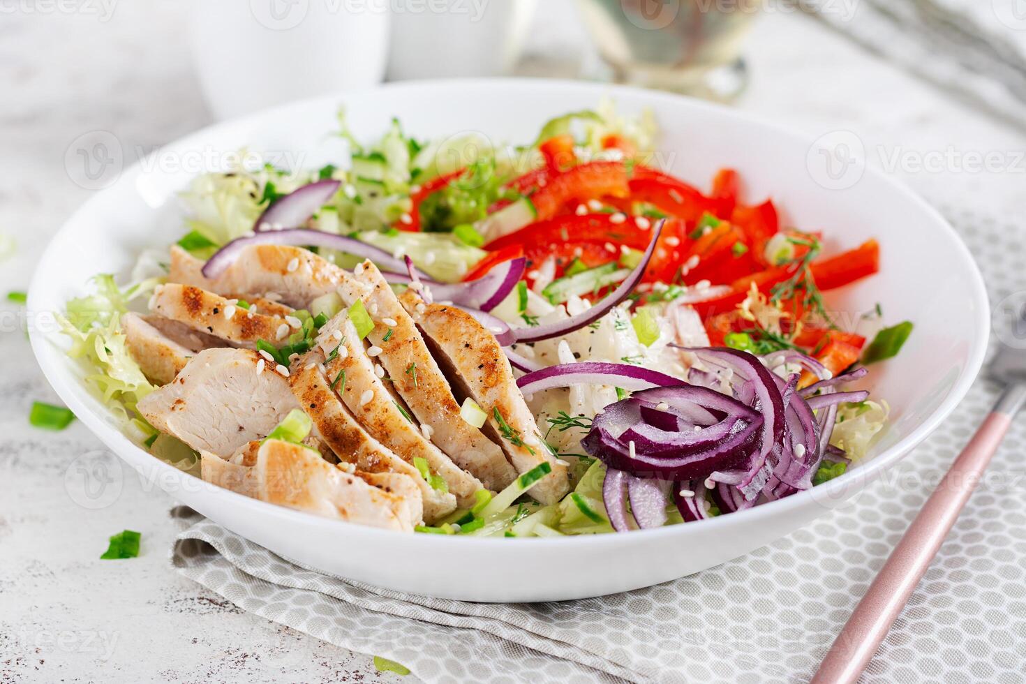 fresco salada com grelhado frango seios, filé e alface, daikon, vermelho cebolas, pepino e sésamo. saudável almoço cardápio. dieta Comida. foto