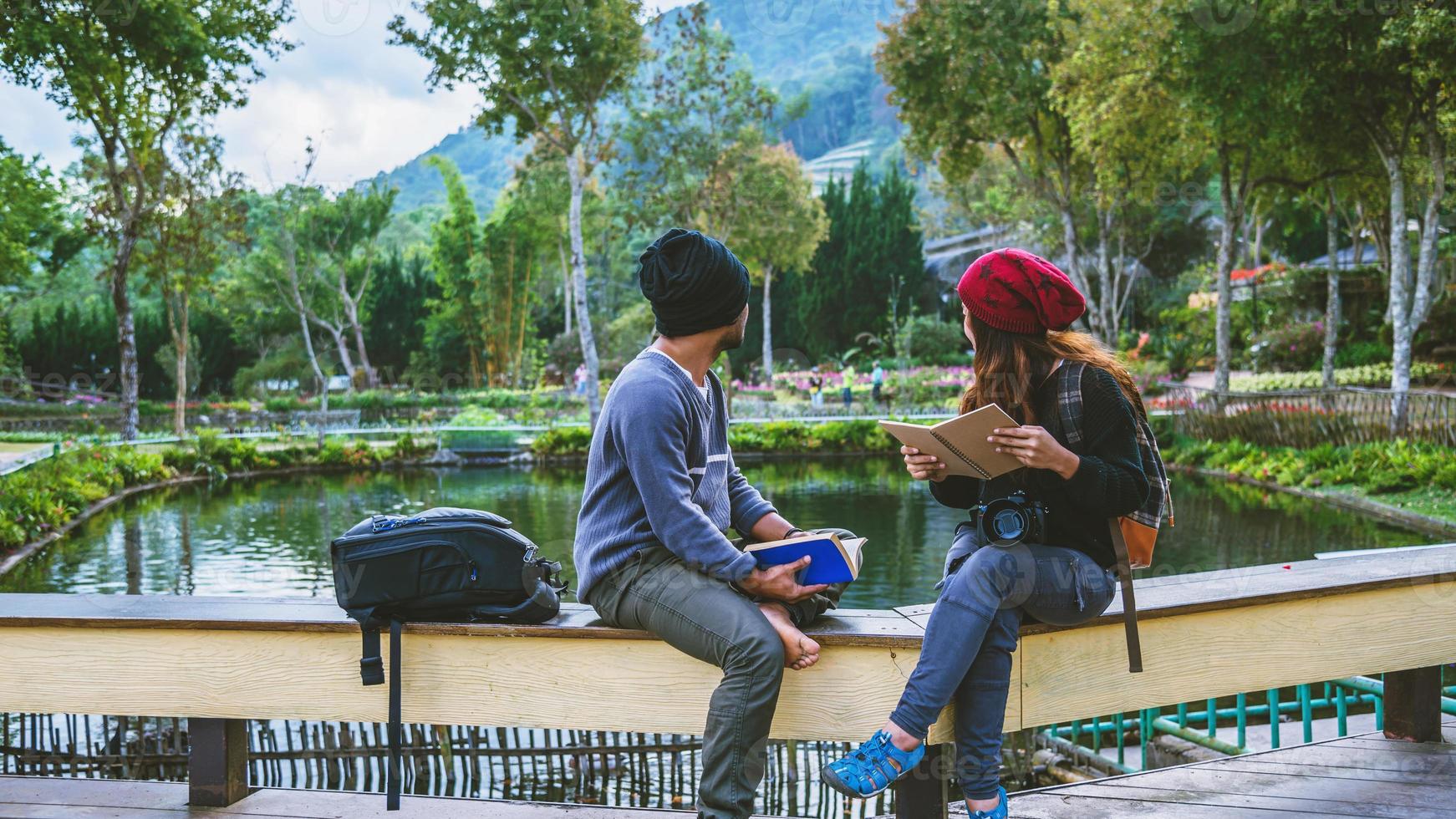 casal asiático viajar fotografia natureza educação. natureza relaxar e estudar ler um livro. no parque público. Na Tailândia foto