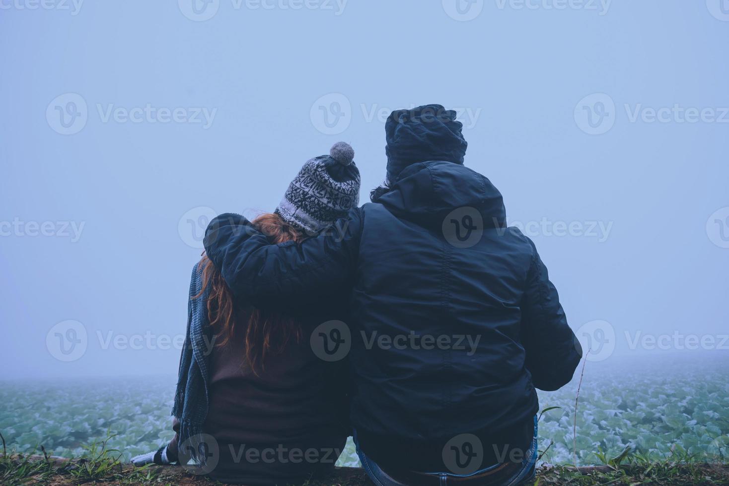 amantes, mulheres e homens asiáticos viajam relaxam no feriado. feliz em viajar no feriado. amantes caminham de mãos dadas no campo de arroz. durante o inverno nebuloso foto