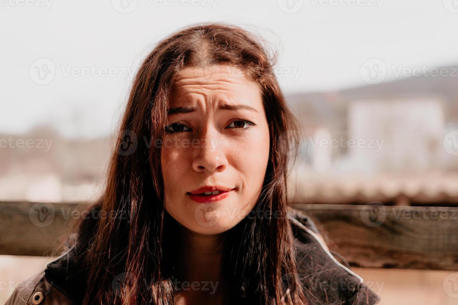 feliz jovem sorridente mulher com sardas ao ar livre retrato. suave ensolarado cores. ao ar livre fechar-se retrato do uma jovem morena mulher e olhando para a Câmera, posando contra outono natureza fundo foto