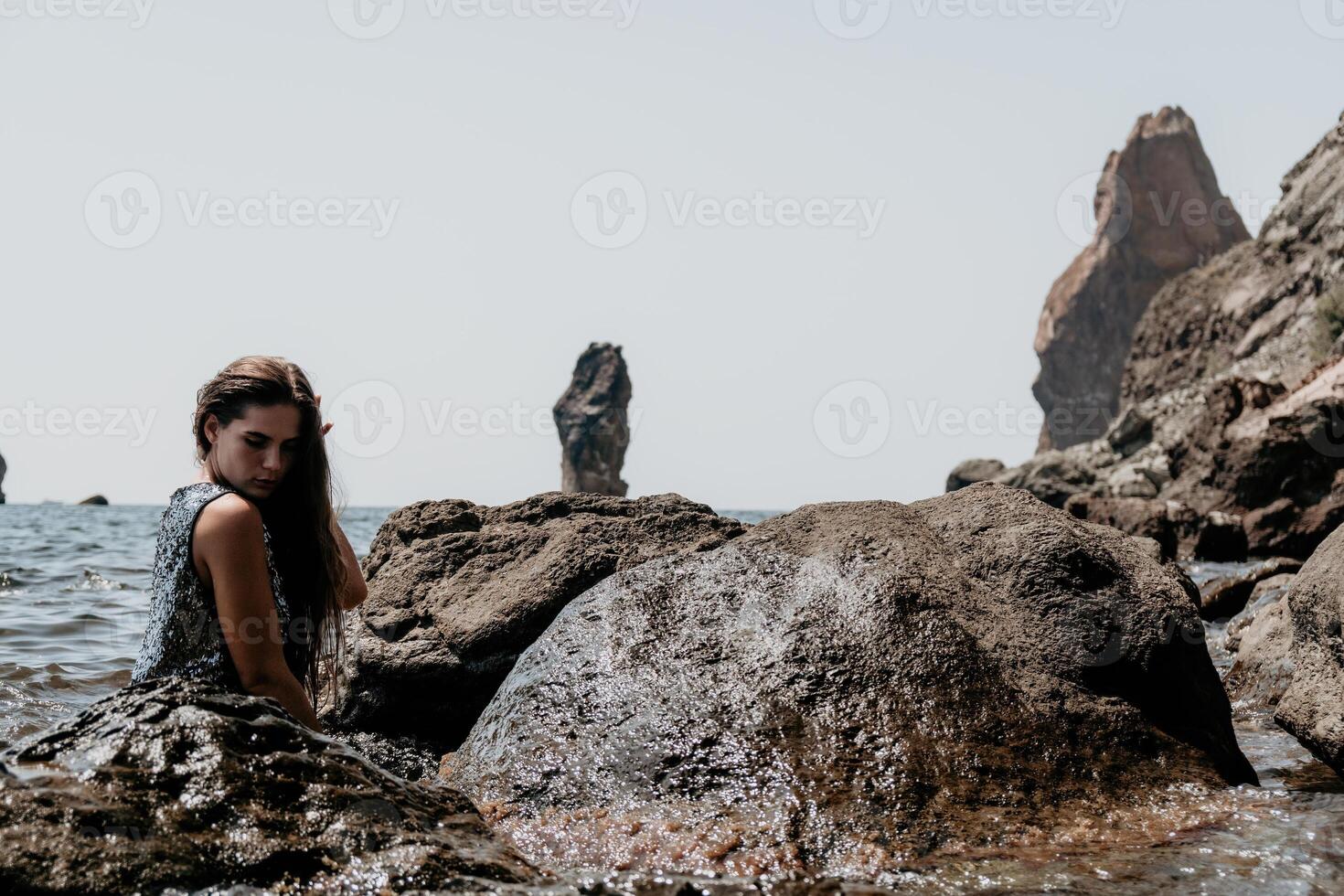 mulher verão viagem mar. feliz turista apreciar levando cenário ao ar livre para recordações. mulher viajante posando em a de praia às mar cercado de vulcânico montanhas, partilha viagem aventura viagem foto