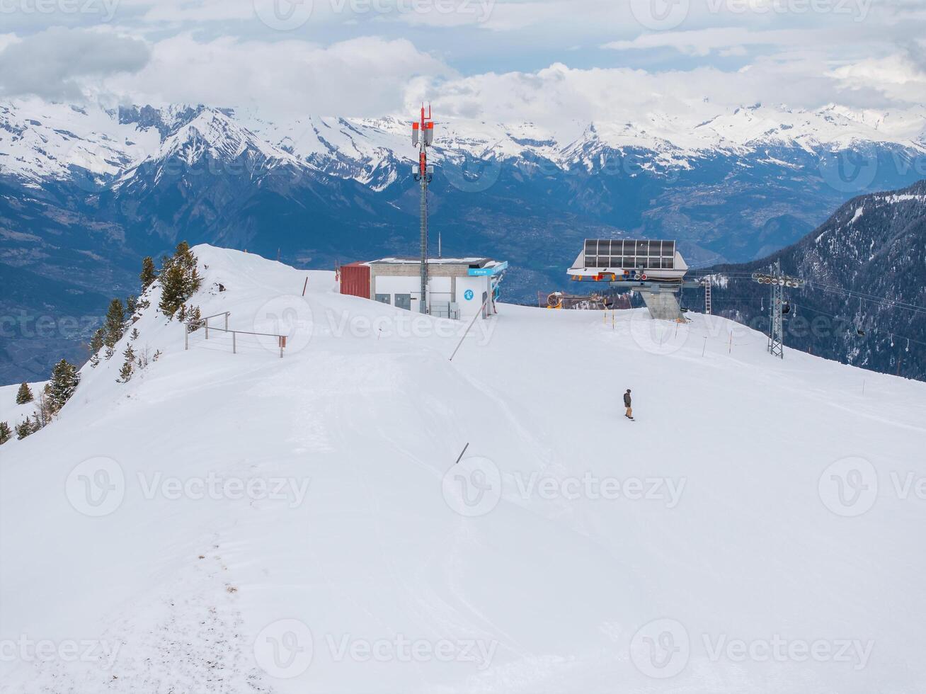 solitário esquiador em uma preparado declive dentro verboso, Suíça no meio Nevado Alpes foto