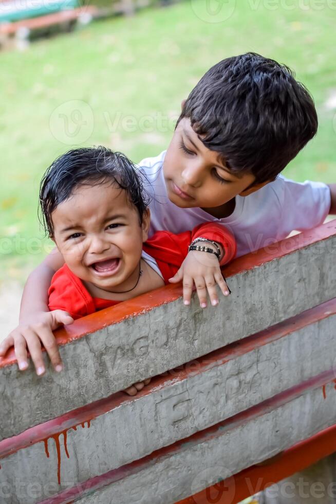 dois feliz Rapazes dentro sociedade parque, feliz ásia irmãos quem estão sorridente alegremente junto. irmãos jogar ao ar livre dentro verão, melhor amigos. criança pequena bebê Garoto jogando com dele feliz irmão dentro a jardim foto