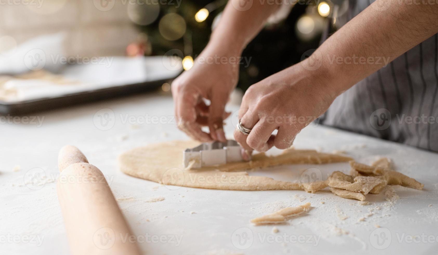 mulher sorridente na cozinha fazendo biscoitos de natal foto
