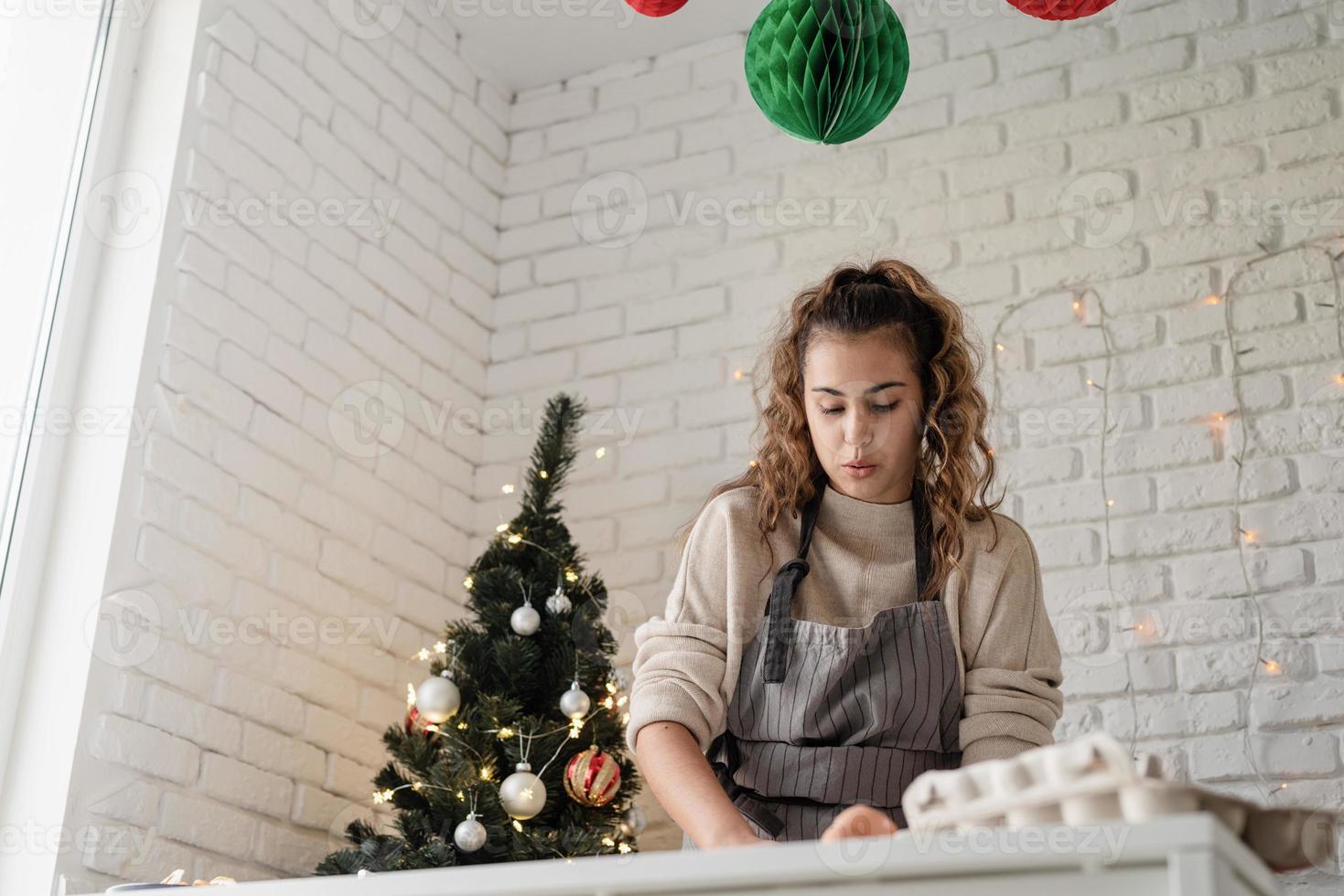 mulher sorridente na cozinha fazendo biscoitos de natal foto