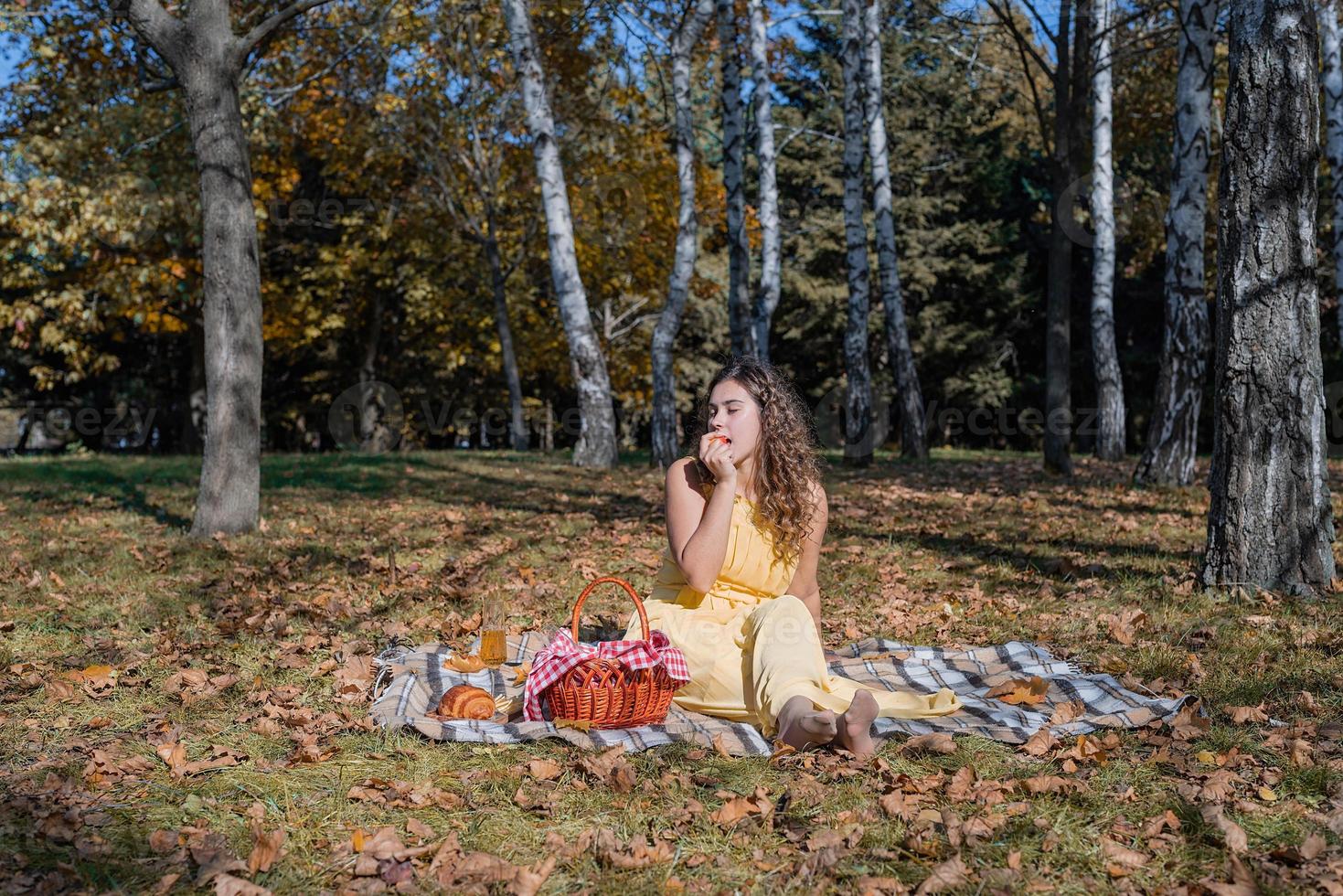 linda mulher em um vestido amarelo em um piquenique foto