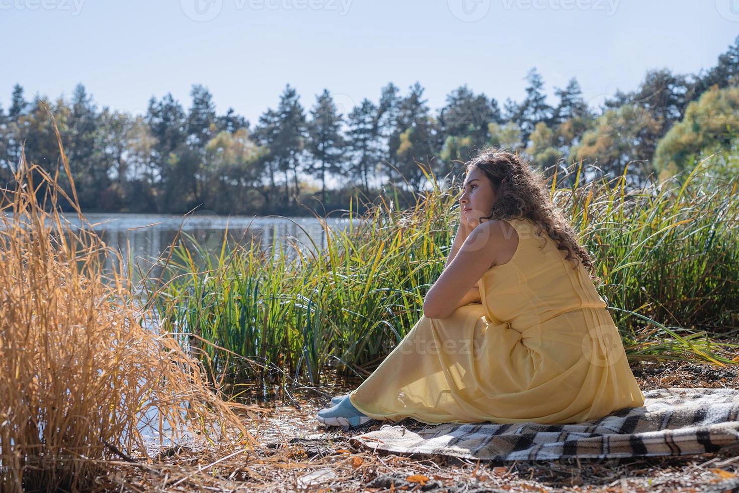 linda mulher em um vestido amarelo em um piquenique foto