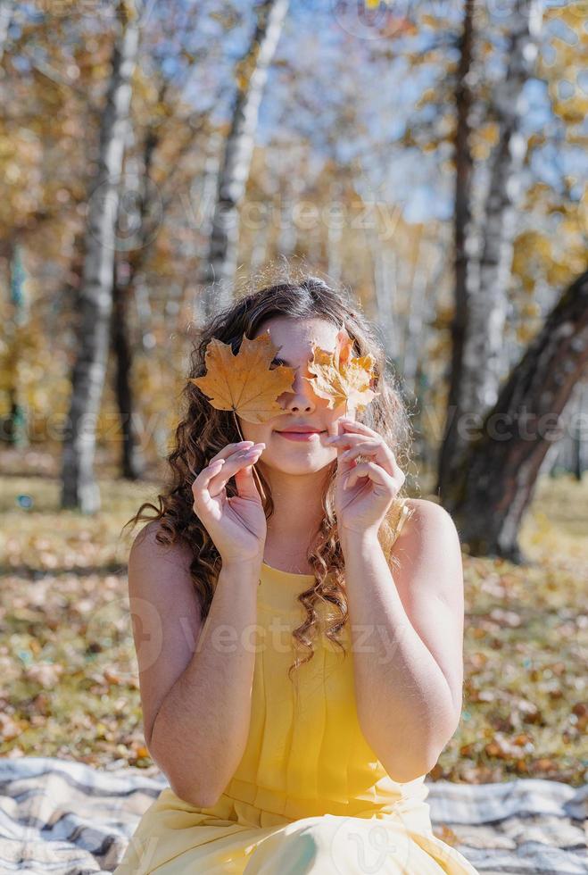 linda mulher em um vestido amarelo em um piquenique em uma floresta foto