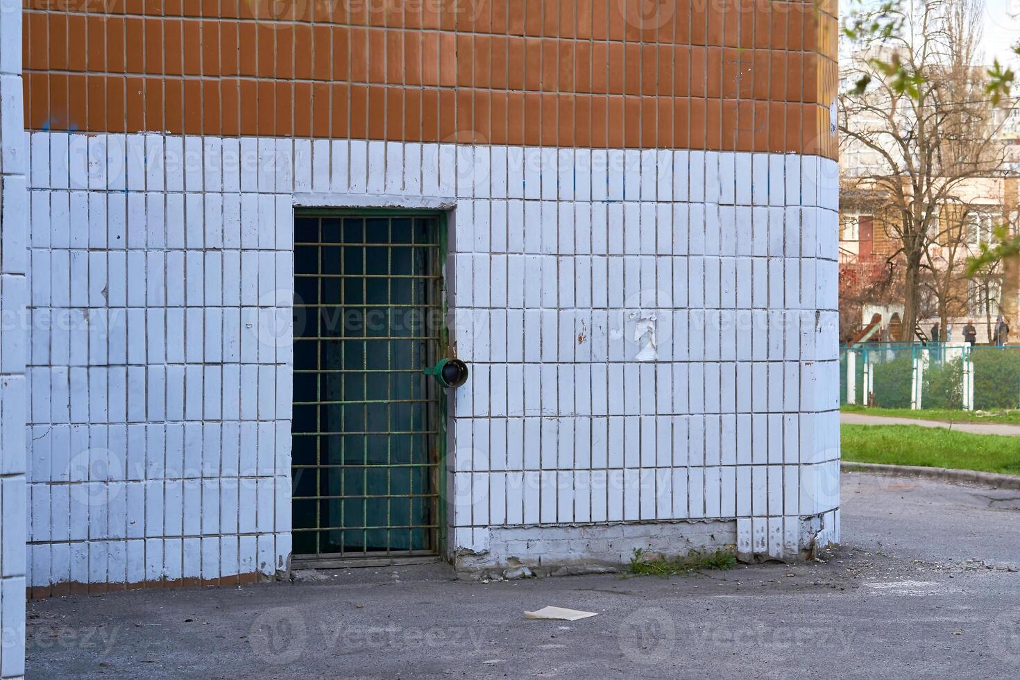 Sombrio metal porta orifício com bares em uma branco lado a lado parede foto