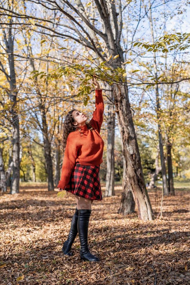 jovem mulher feliz caminhando na floresta de outono foto