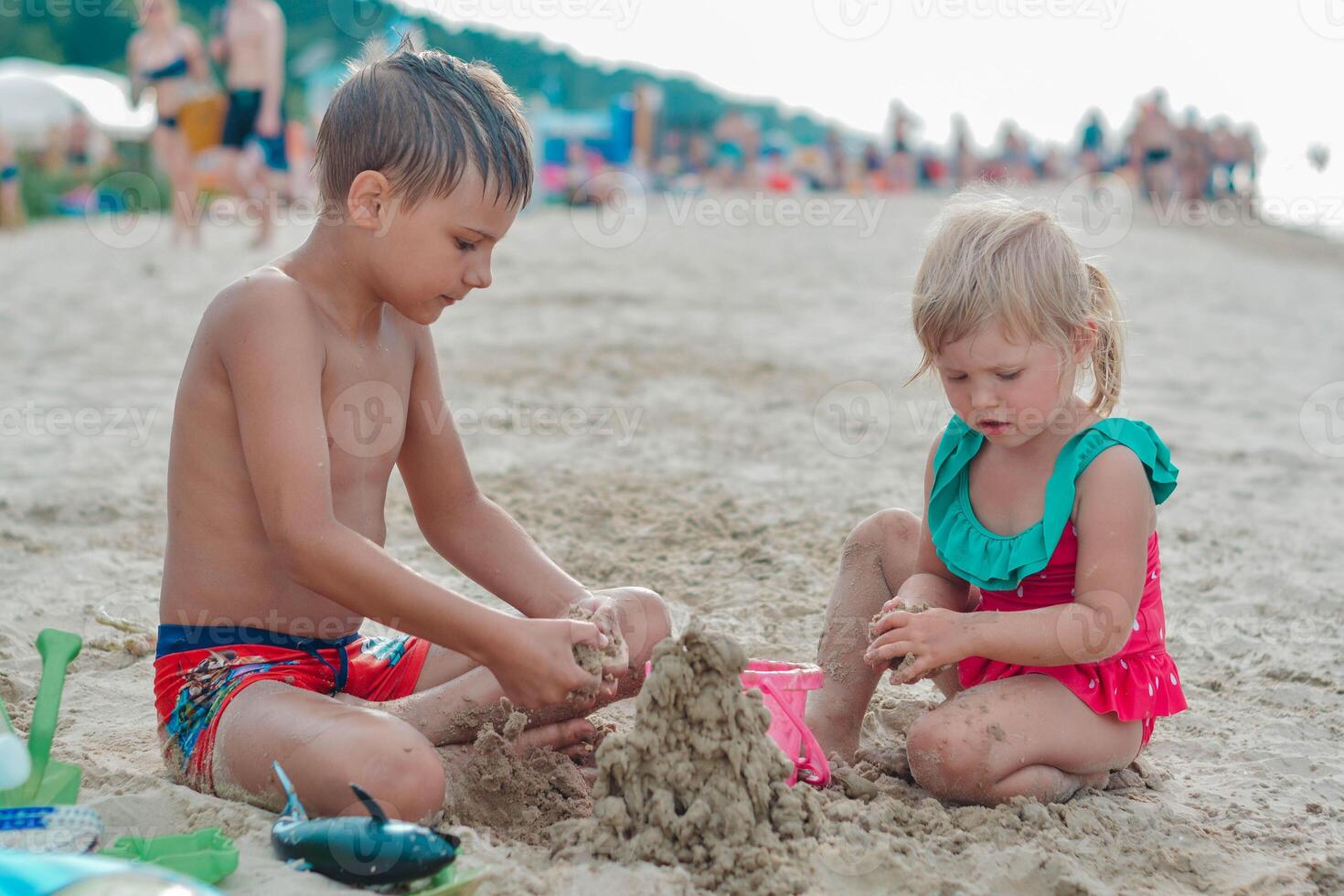 irmão e irmã fazer areia castelo em a de praia dentro caloroso verão dia.família verão feriados conceito. Alto qualidade foto