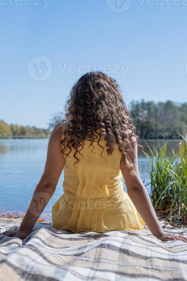 linda mulher em um vestido amarelo em um piquenique foto