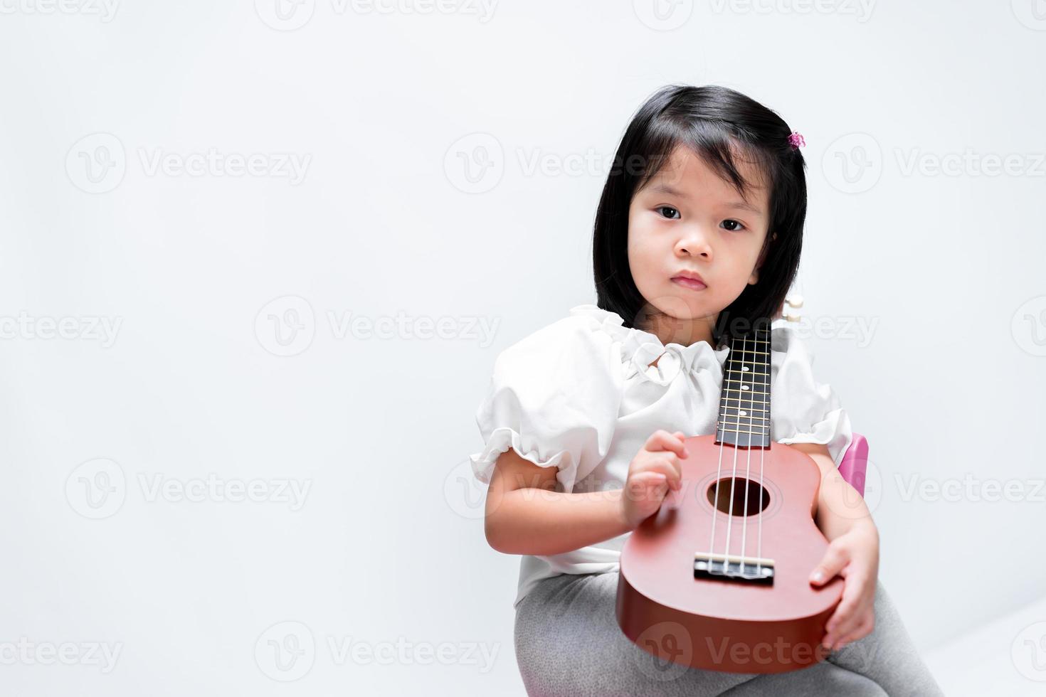 criança aprendendo música ukulele basic. em fundo branco isolado. foto