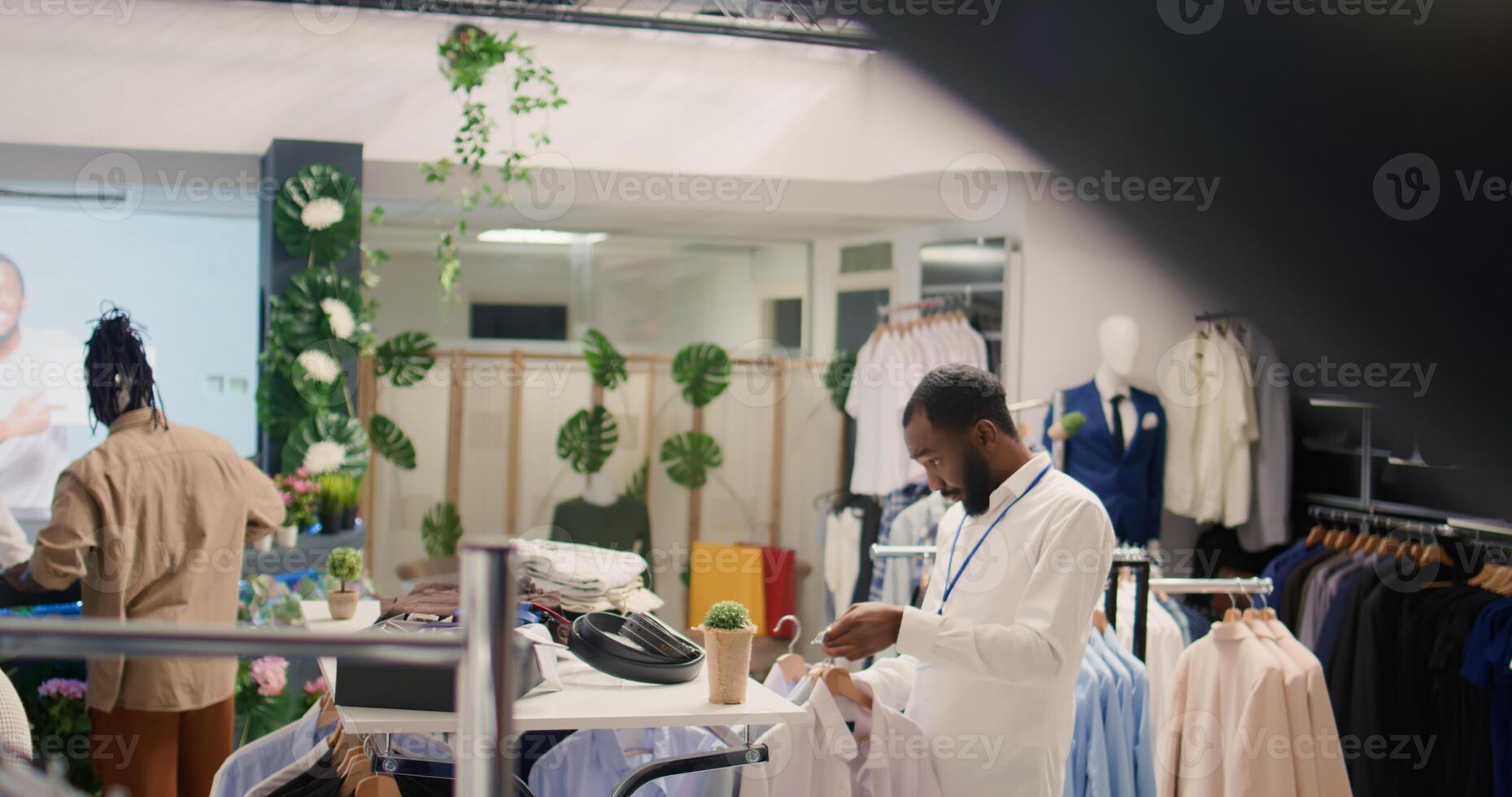 a sobrecarga tiro do empregado arranjo roupa formal roupas em prateleiras dentro roupas loja, Ordenação cada item de em forma tamanho. varejo assistente arranjo vestuário dentro caro moda boutique foto