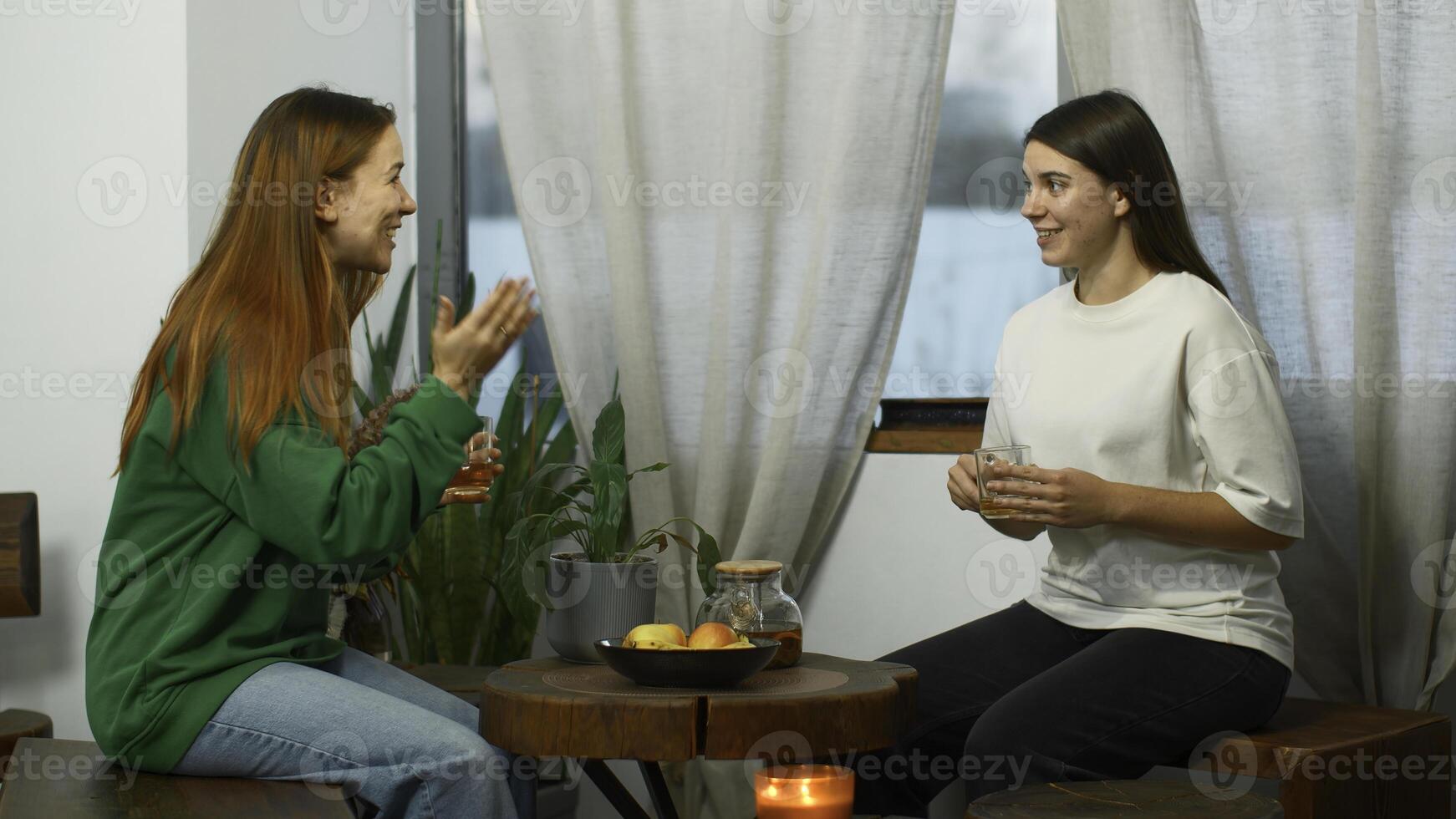 lindo jovem mulheres estão ativamente falando dentro cafeteria. meios de comunicação. amigos estão tendo Diversão falando dentro acolhedor aluna cafeteria. amigos beber chá e ter Diversão conversando em aluna pausa foto