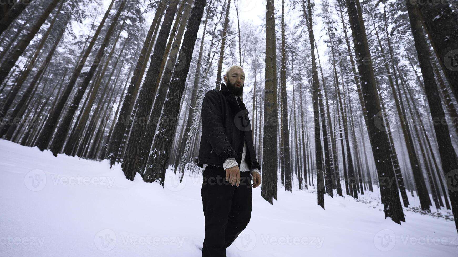 homem dançando dentro inverno floresta. meios de comunicação. à moda homem filmando vídeo grampo dentro inverno floresta. tiroteio à moda homem dentro inverno floresta foto