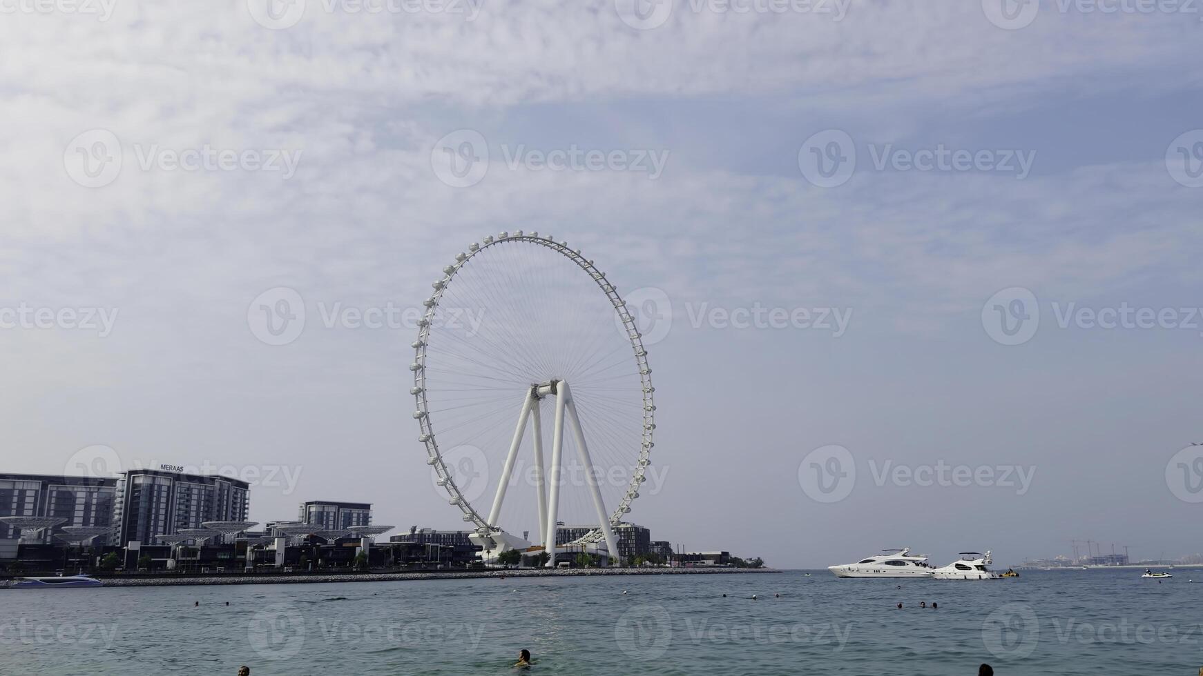 surpreendente marinho panorama com branco gigante observação roda. Ação. de praia com natação pessoas, iate, e a ferris roda. foto