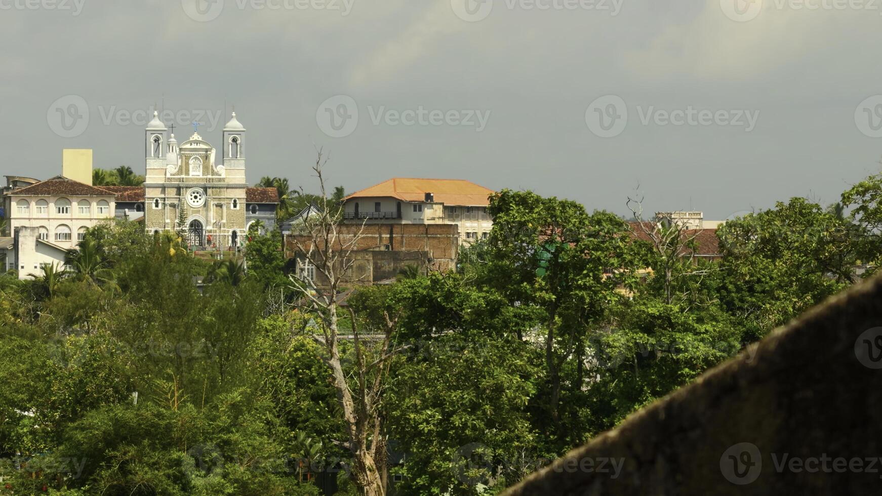 telhados do edifícios e cinzento céu. Ação. vermelho telhados e verde árvores em uma verão dia. foto