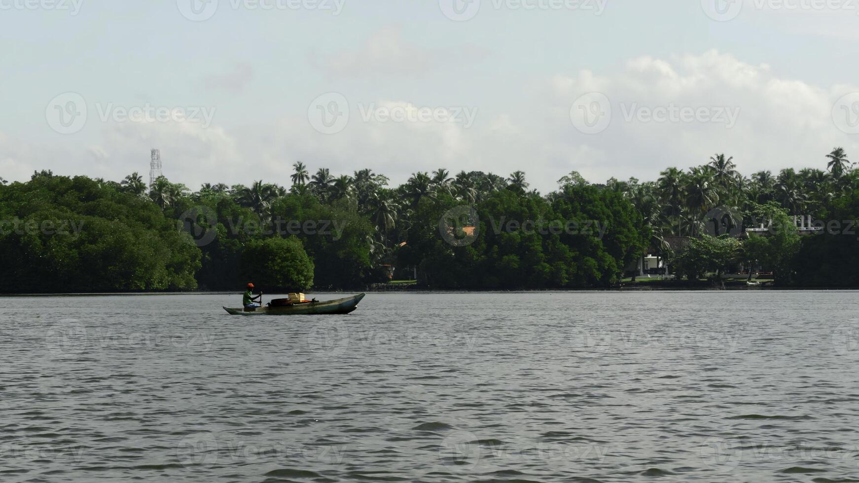 pescador dentro uma barco Navegando dentro Largo rio. Ação. pequeno barco e verde arborizado costa. foto