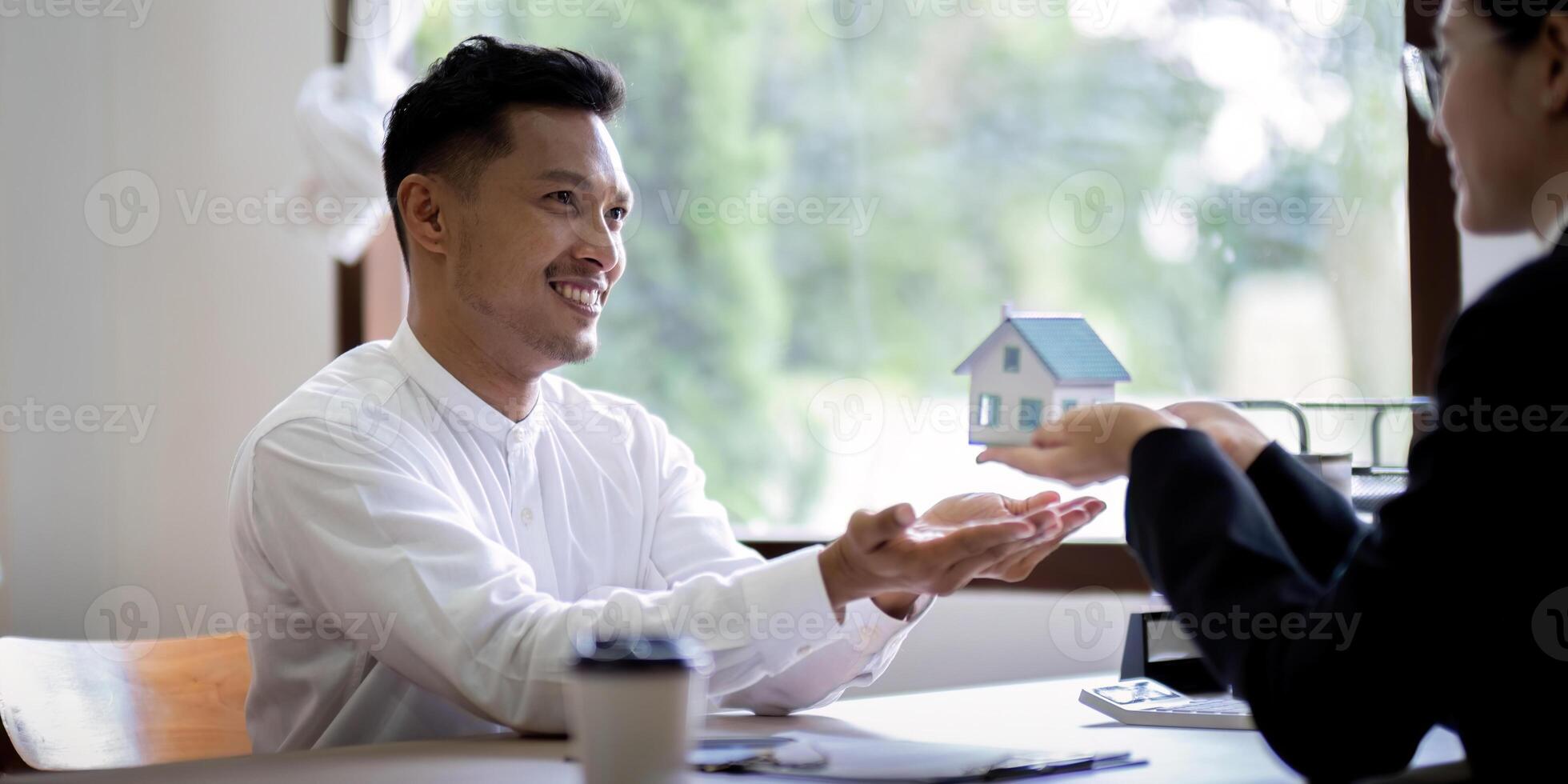 cliente Conheça e negociação com real Estado agentes sobre alugar, comprando lar, real Estado agente negociar, conversa sobre a termos do a casa compra acordo e Perguntou cliente para placa contrato foto