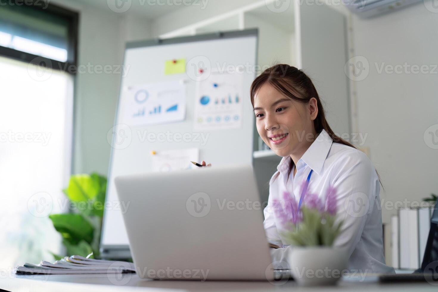 ásia o negócio mulher usando computador portátil para análise gráfico financeiro despesas relatório e planejamento para futuro dentro escritório escrivaninha foto