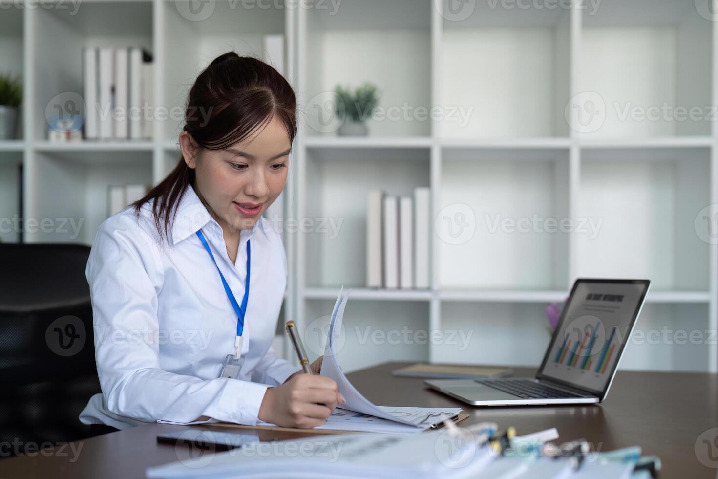 ásia o negócio mulher usando computador portátil para análise gráfico financeiro despesas relatório e planejamento para futuro dentro escritório escrivaninha foto