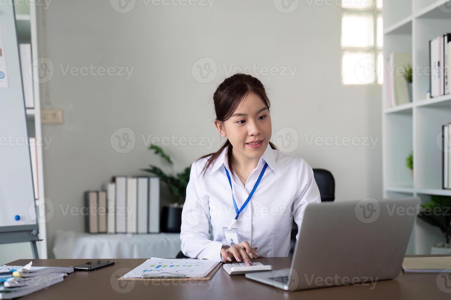 ásia o negócio mulher usando computador portátil para análise gráfico financeiro despesas relatório e planejamento para futuro dentro escritório escrivaninha foto