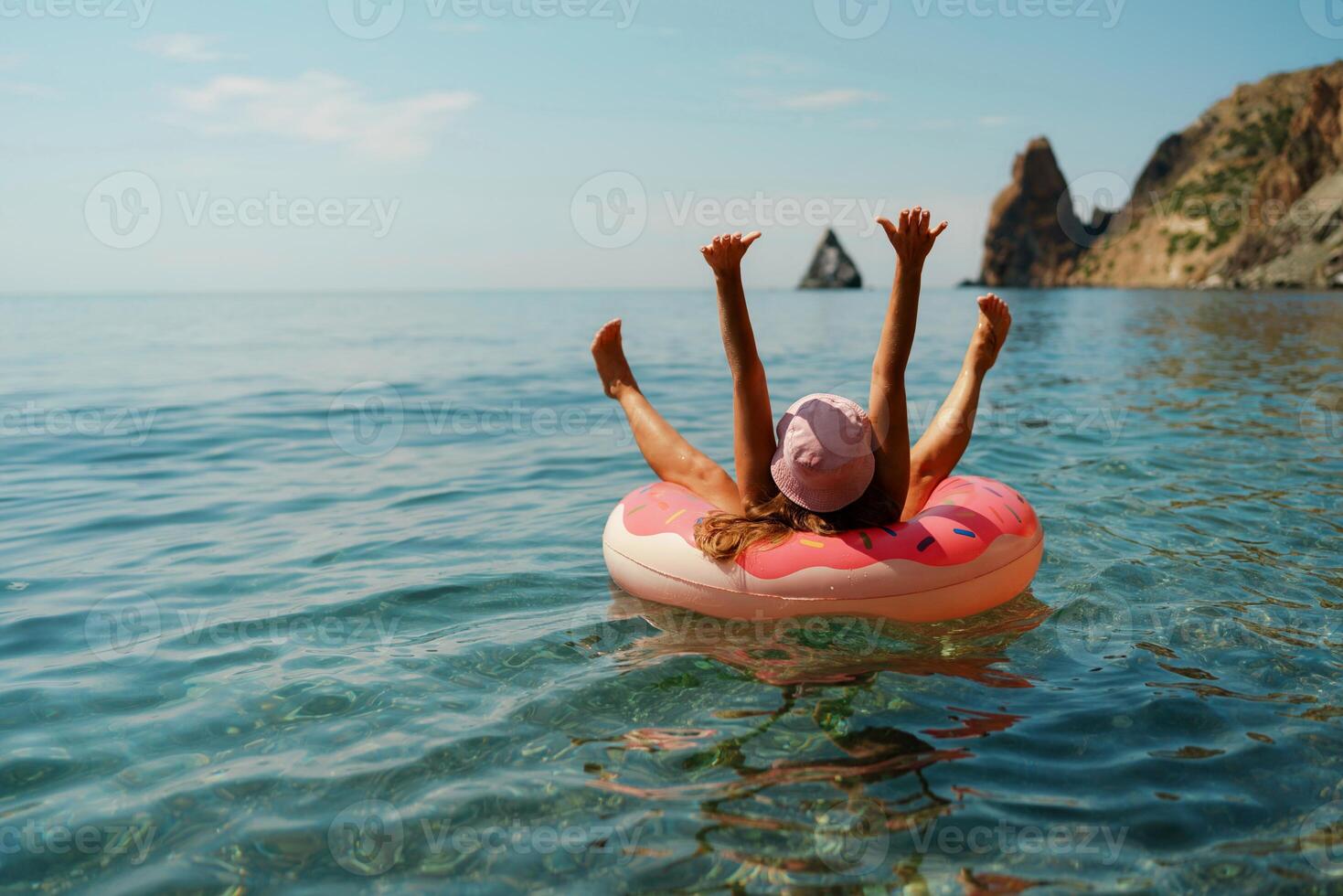 verão período de férias mulher dentro chapéu flutua em a inflável rosquinha colchão. feliz mulher relaxante e desfrutando família verão viagem feriados viagem em a mar. foto