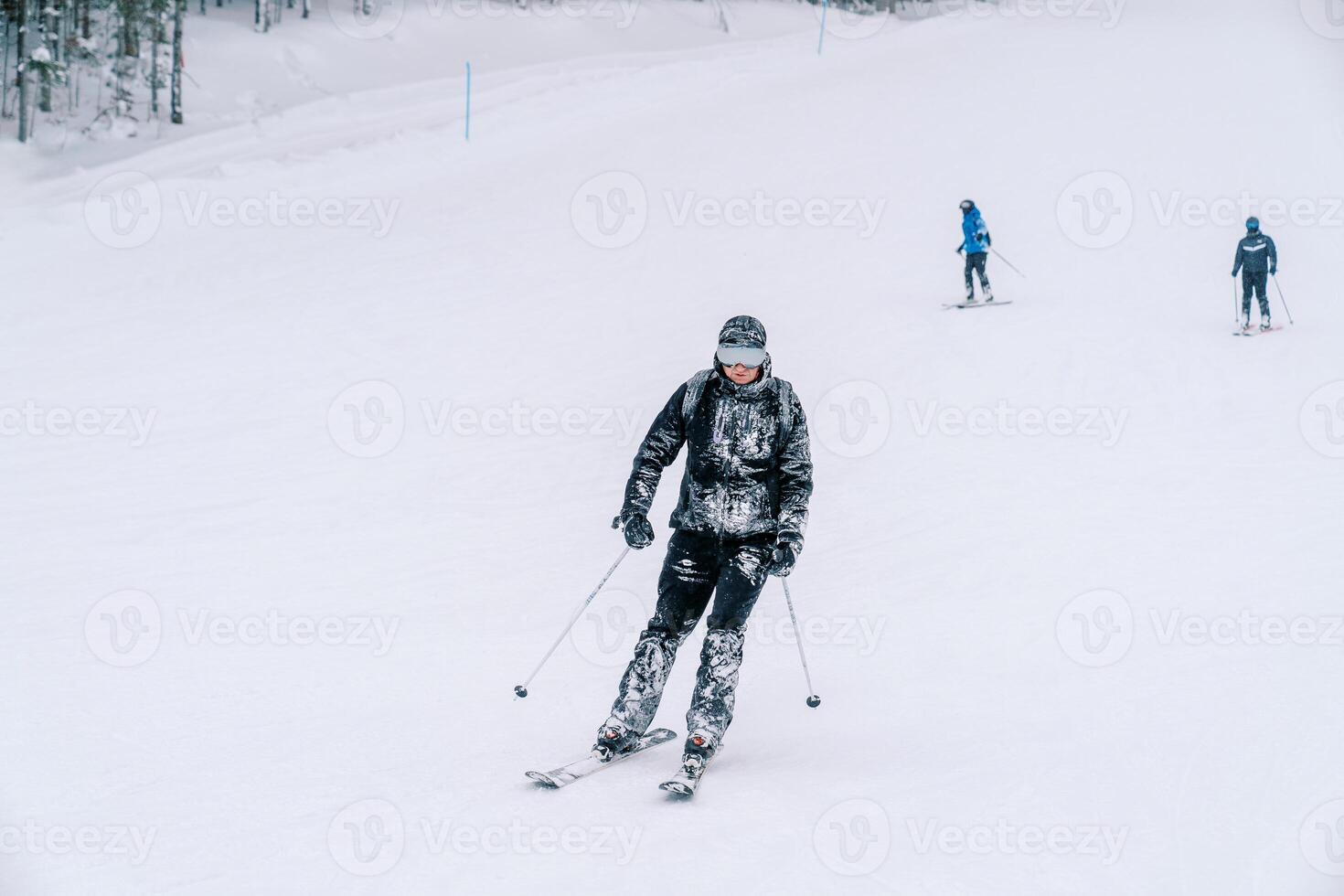 coberto de neve esquiador dentro óculos passeios baixa a montanha declive foto