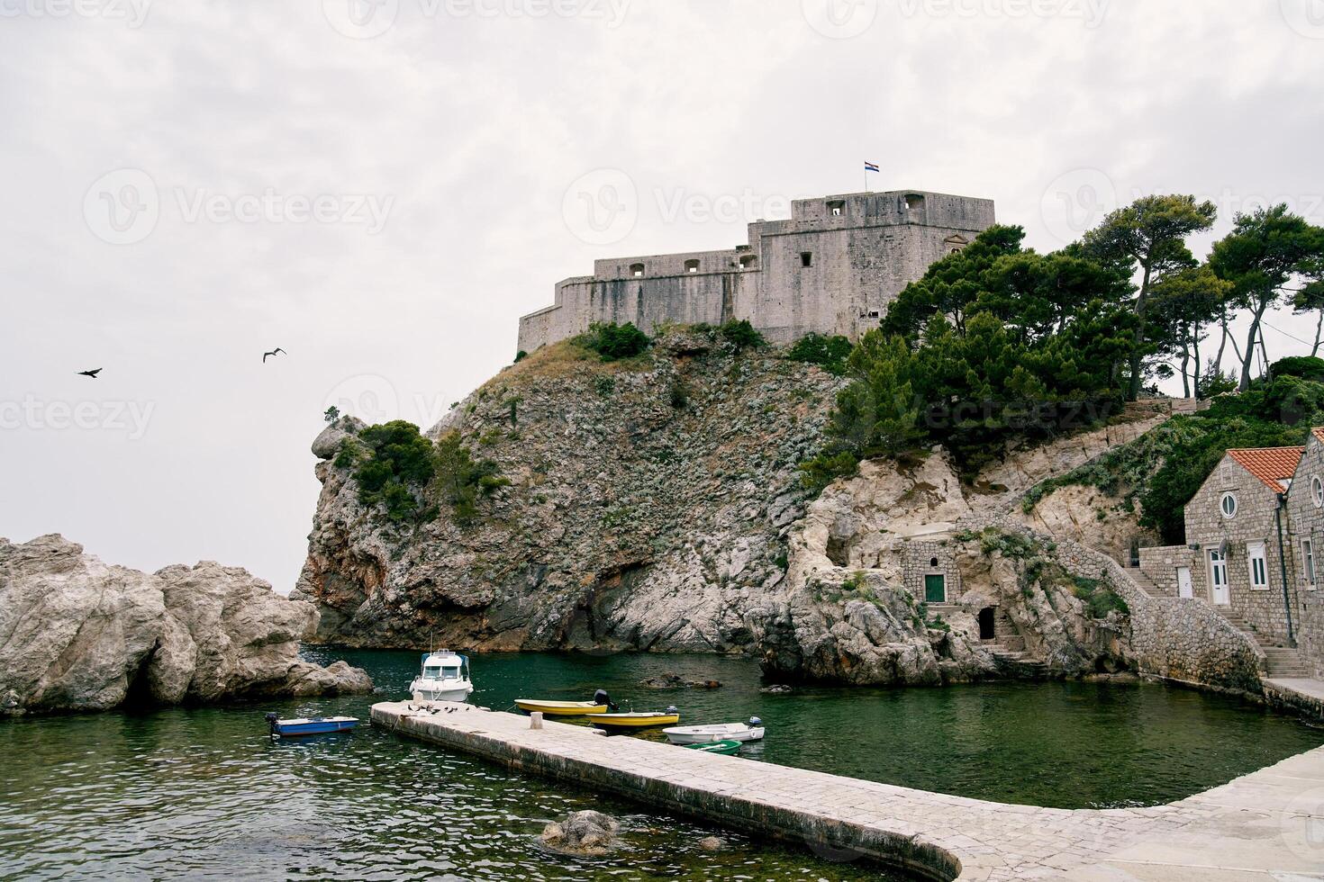 barcos estão ancorado dentro uma pequeno baía perto a fortaleza muro. dubrovnik, Croácia foto