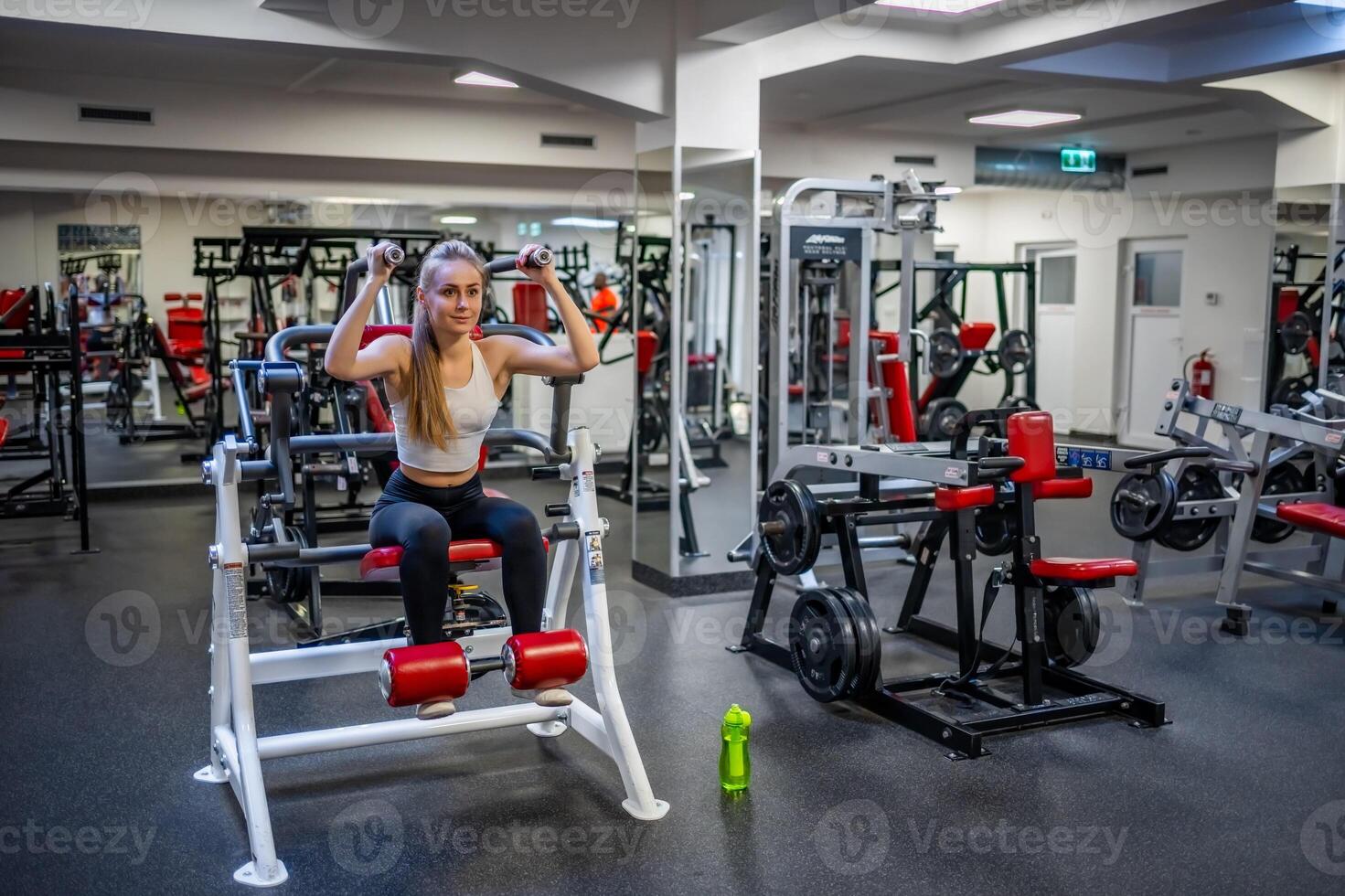 jovem esporte mulher vestindo esporte vestem fazendo exercício com ginástica equipamento às academia, ela exercício para Forte e Boa saudável. Alto qualidade foto