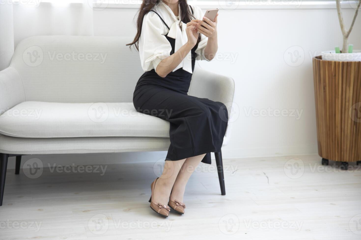 uma japonês mulher verificação Smartphone dentro a casa escritório sem rosto composição foto