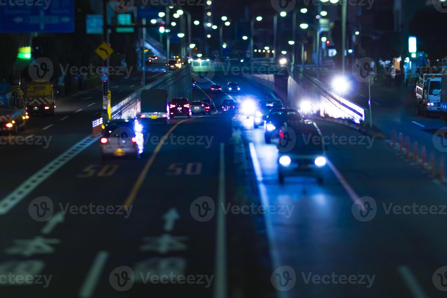 uma noite miniatura tráfego geléia às a urbano rua dentro Tóquio foto