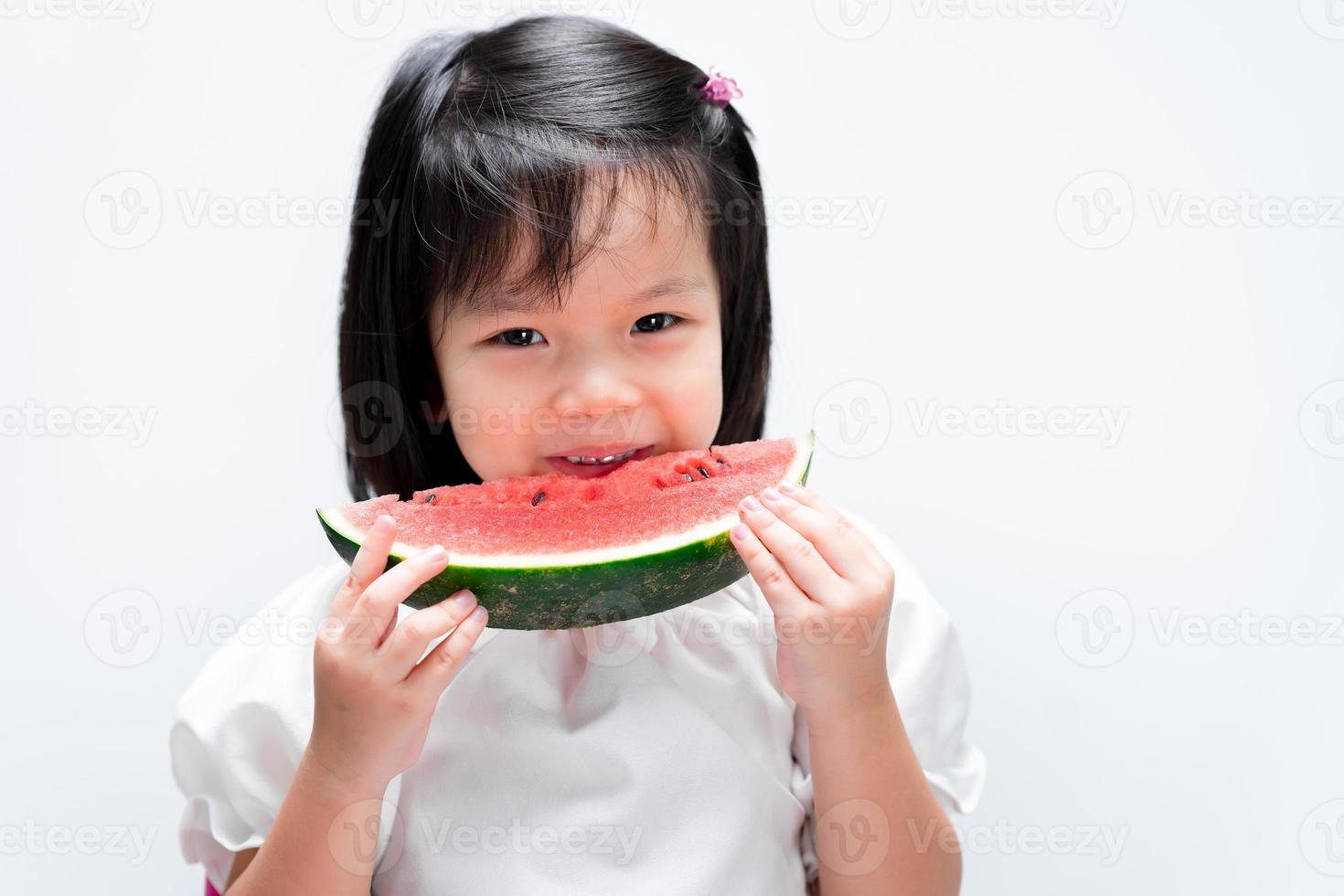 menina criança feliz comendo melancia. alimentação saudável da criança. conceito de frutas de verão. foto