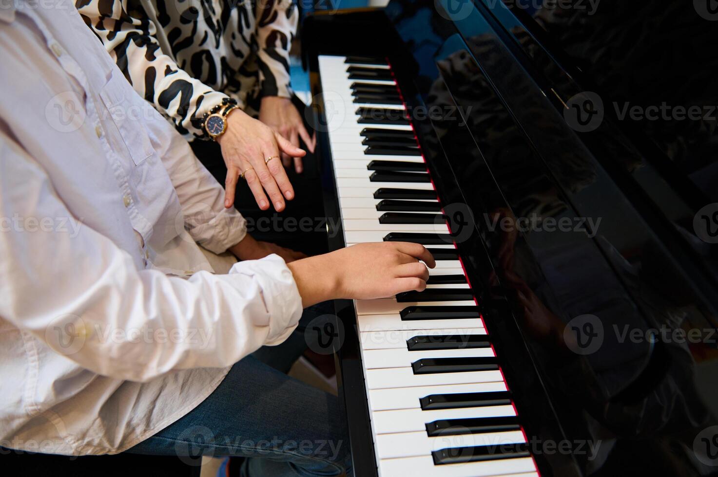 seletivo foco para Adolescência Garoto músico pianista dedos e piano chave para jogar a piano. fechar-se criança jogando a piano durante Individual música lição debaixo dele professores orientação foto