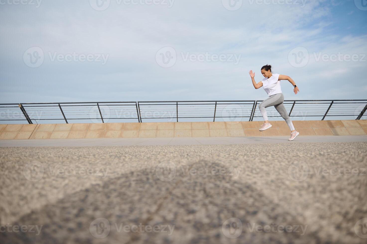 cheio comprimento retrato do Atlético mulher corrida corrida correndo em cidade ponte durante consciência maratona. cópia de espaço foto