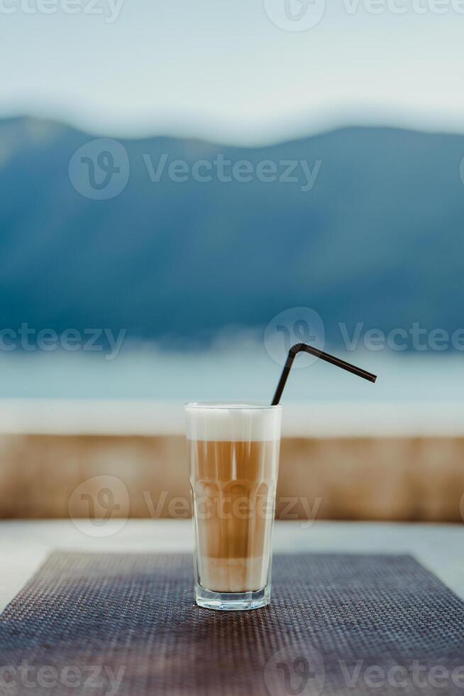 vidro do frappe com uma Palha em uma mesa dentro uma cafeteria foto