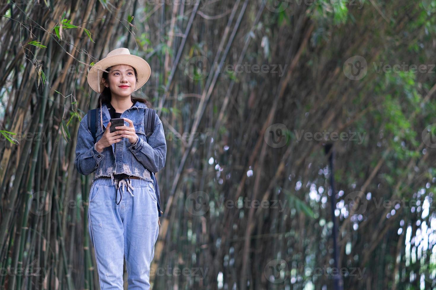 jovem mulher asiática explora a floresta no feriado foto