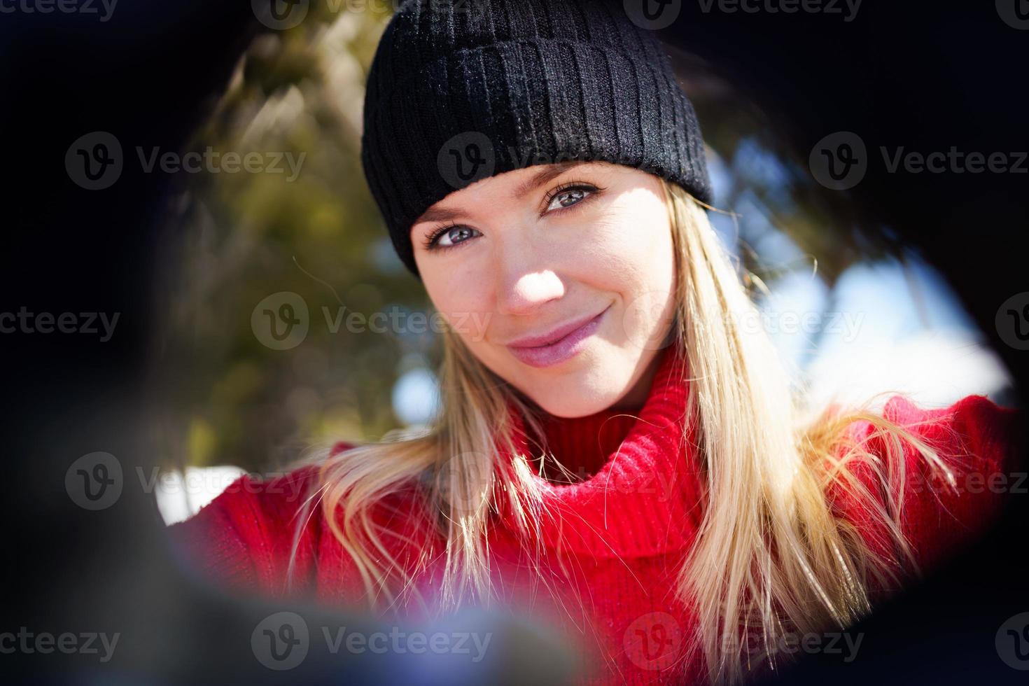 jovem loira tomando uma selfie em uma floresta de montanhas nevadas no inverno. foto