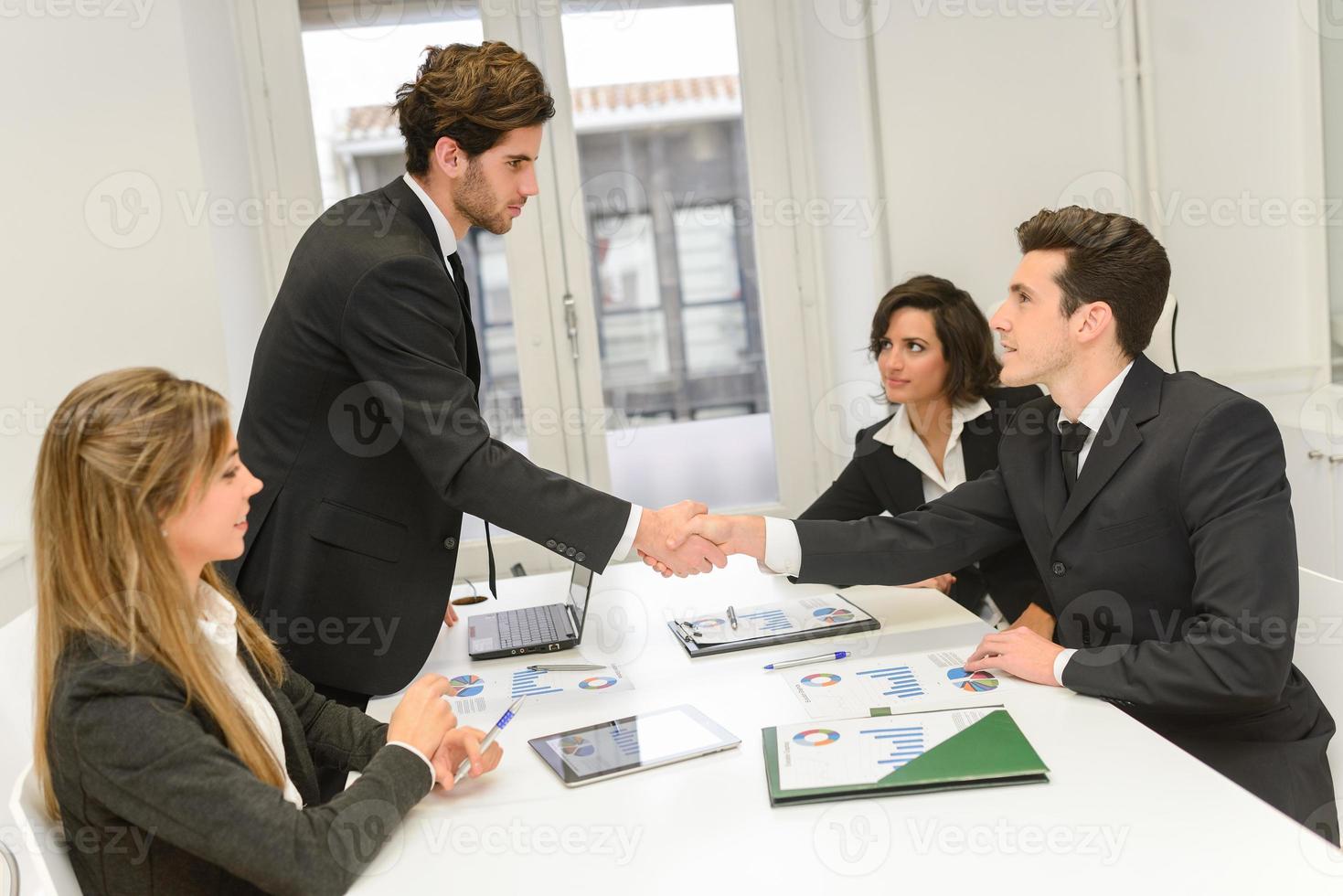 Empresários apertando as mãos, terminando uma reunião foto