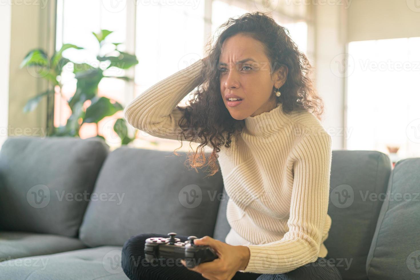 mulher laitin jogando videogame com as mãos segurando um joystick foto