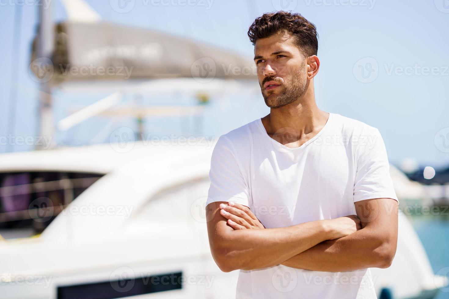 modelo de fitness em roupa esportiva, posando no porto à beira-mar. foto