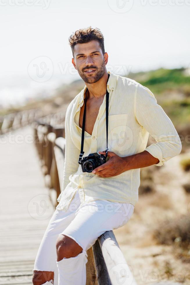 homem bonito fotografando em uma área costeira. foto