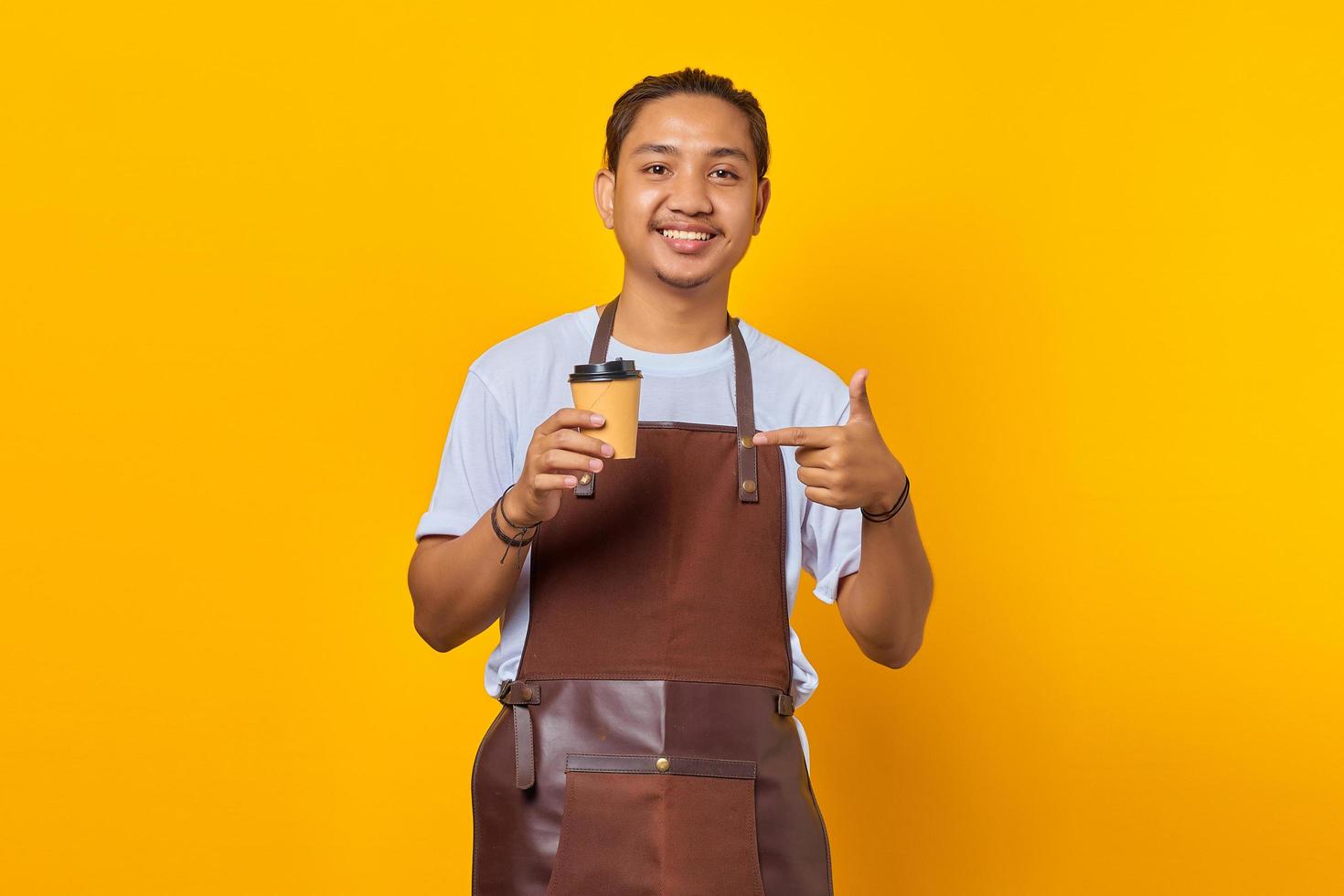 retrato de homem alegre e positivo segurando o copo de papel com o dedo, mostrando o desconto nas vendas sobre fundo amarelo foto